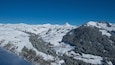 A snow-covered mountain range with a clear blue sky.