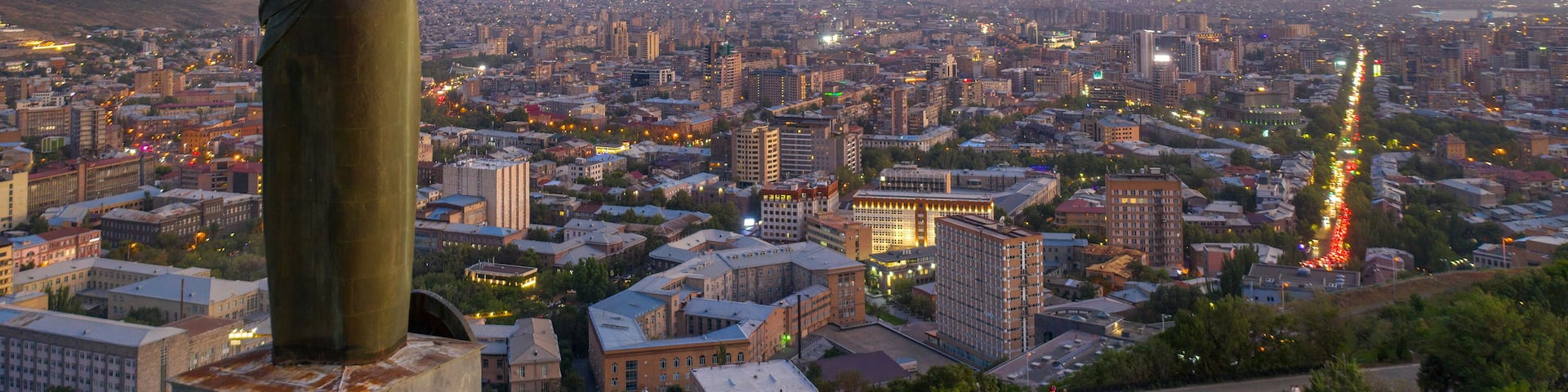 View of Mother Armenia Statue, Eternal Fire in Akhtanak Park and the city in the evening. Yerevan, Armenia.