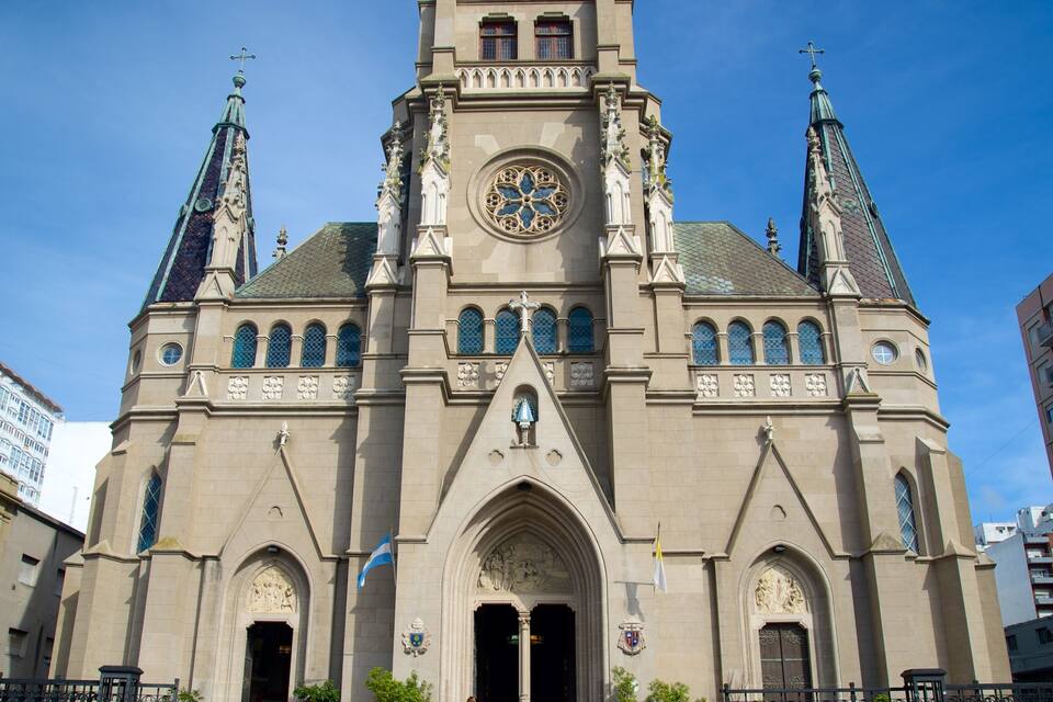 A historic church with twin spires, a large rose window, and a clock tower.
