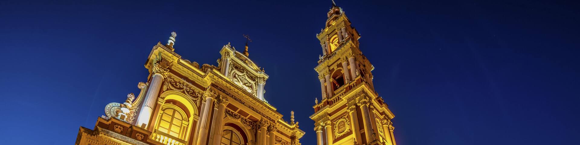 Una catedral imponente e iluminada, con arquitectura detallada y una alta torre campanario.