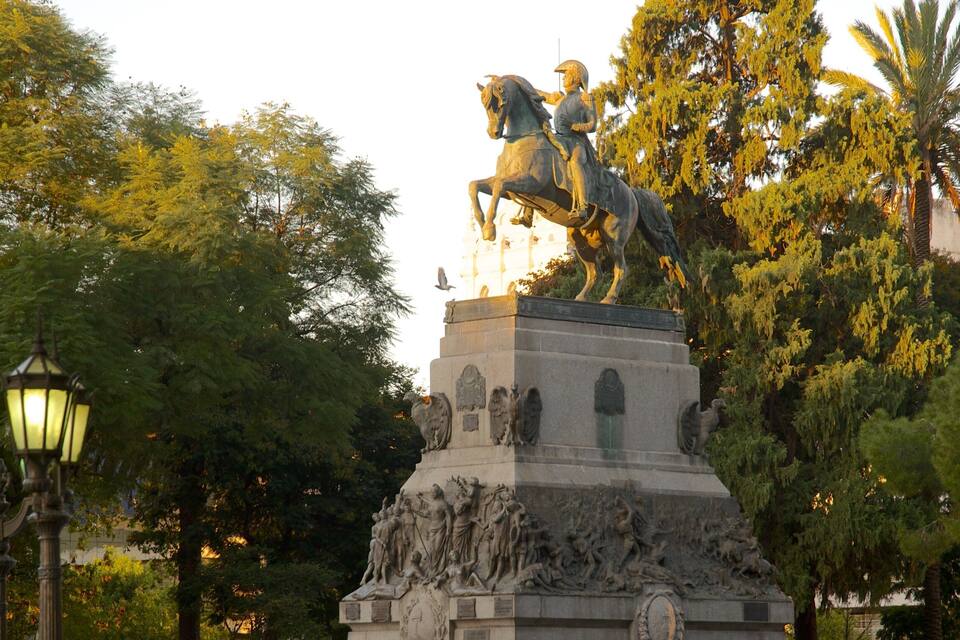 A statue of a man on horseback surrounded by a detailed base sculpture.