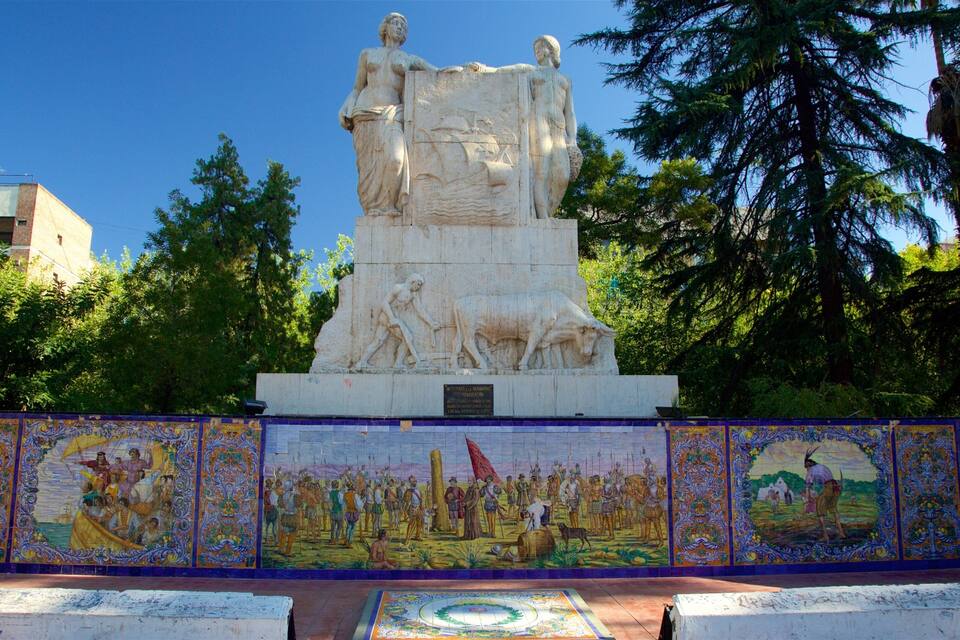 A large stone monument with a relief sculpture of a man and a woman, surrounded by a mosaic depicting historical scenes.