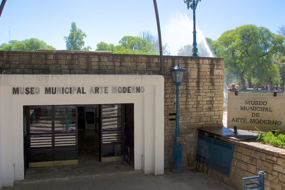 The entrance to Museo Municipal de Arte Moderno with a brick wall and two street lamps.