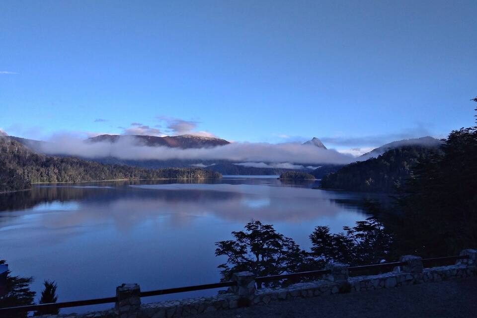 Un lago tranquilo rodeado de montañas y árboles.