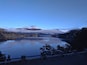 A calm lake surrounded by mountains and trees.