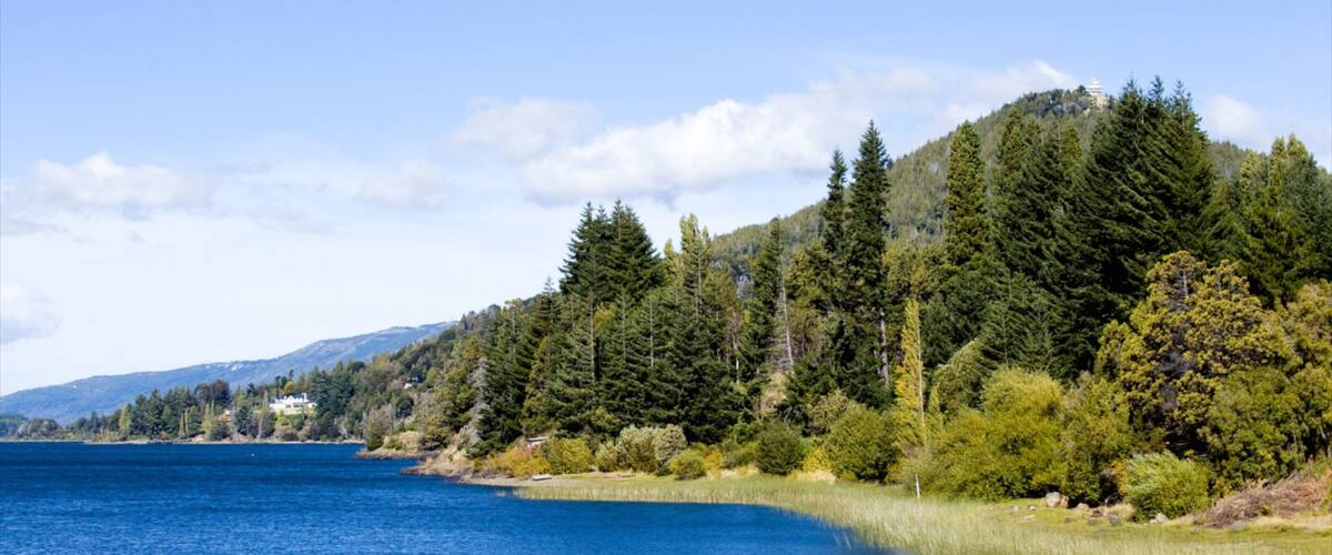 A lake surrounded by dense forest and hills.
