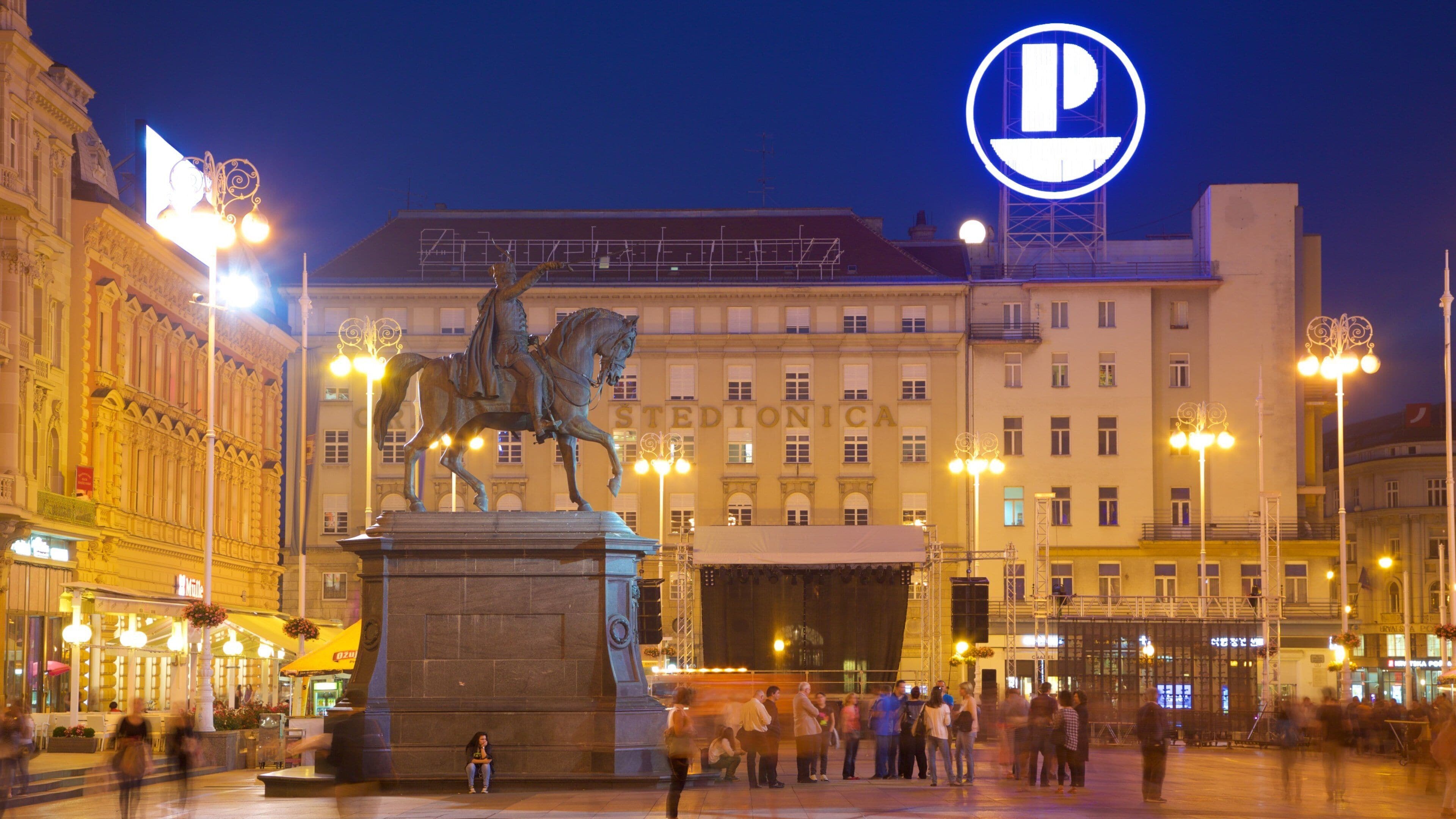 A statue of a man on horseback in a square with a building labeled "STEDIONICA" in the background.