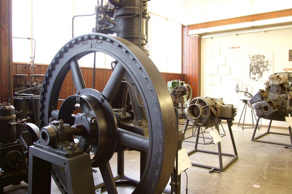 An industrial setting with large machinery, including a prominent wheel and various mechanical components.