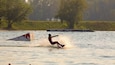 A wakeboarder performing a jump over a wakeboard ramp at Wake Park.