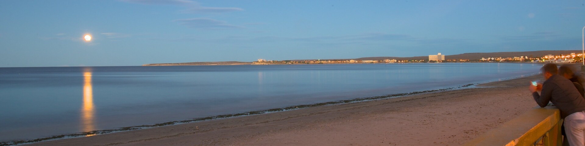Puerto Madryn Beach which includes general coastal views, a sunset and a sandy beach