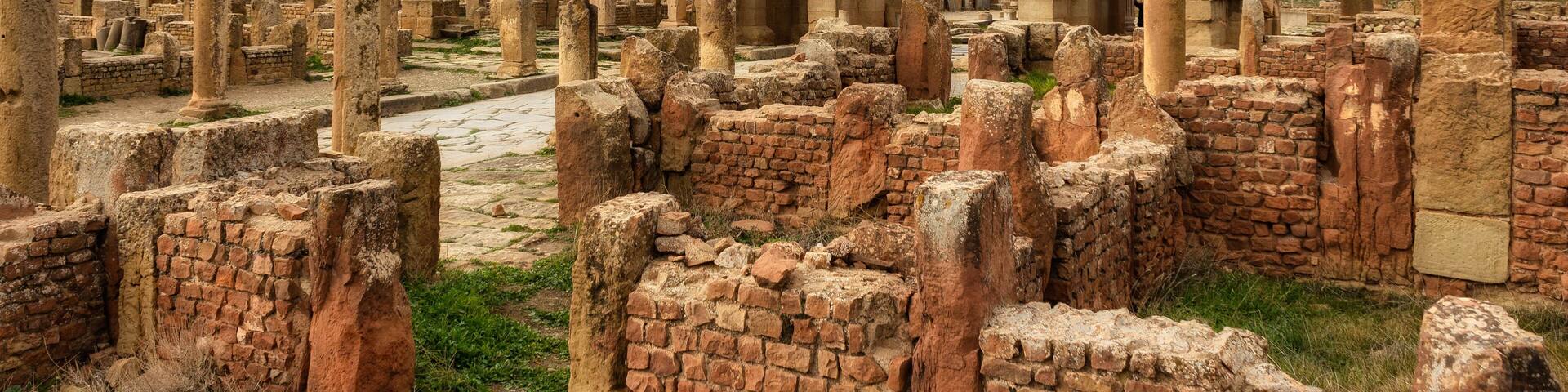 Ancient ruins with a prominent archway and columns.
