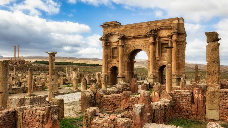 Ancient ruins with a prominent archway and columns.