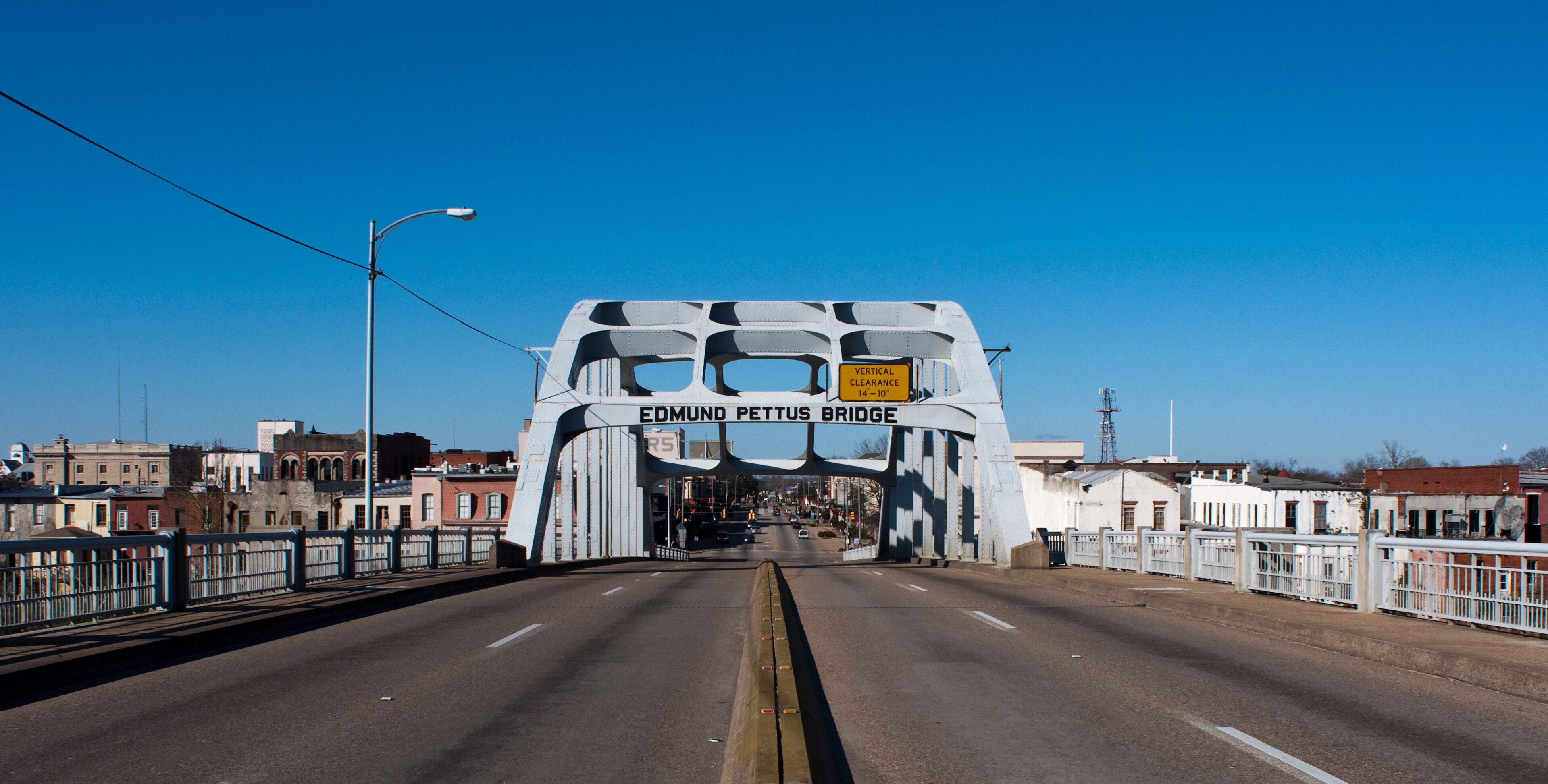 A bridge with the sign 'EDMUND PETTUS BRIDGE' and a vertical clearance sign.