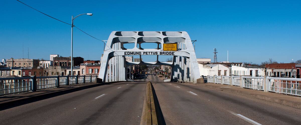 A bridge with the sign 'EDMUND PETTUS BRIDGE' and a vertical clearance sign.