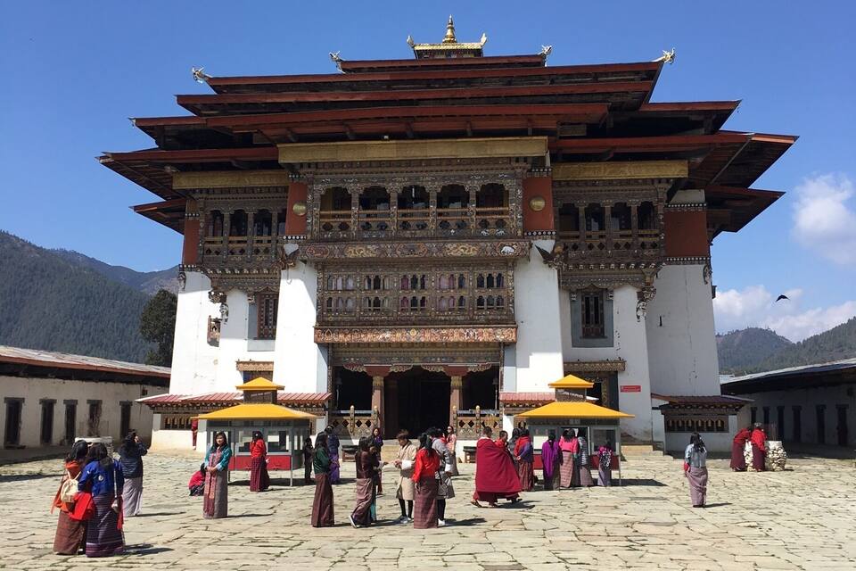 A traditional Tibetan building with ornate architecture and a clear blue sky.
