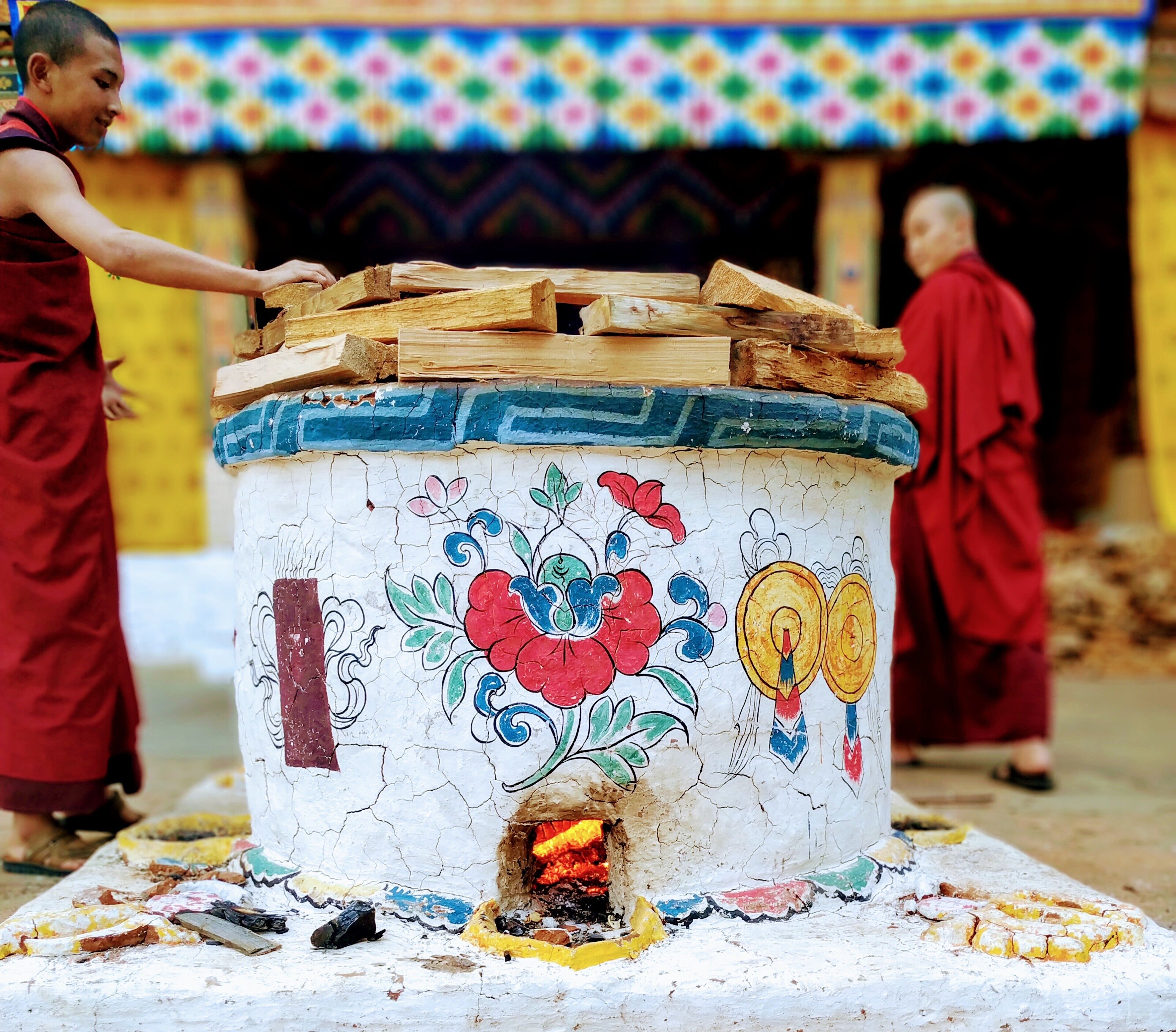 Two monks at Punkaha Dzong are preparing to face a cold winter night by lighting a beautifully decorated fireplace.

#Bhutan #culture 
