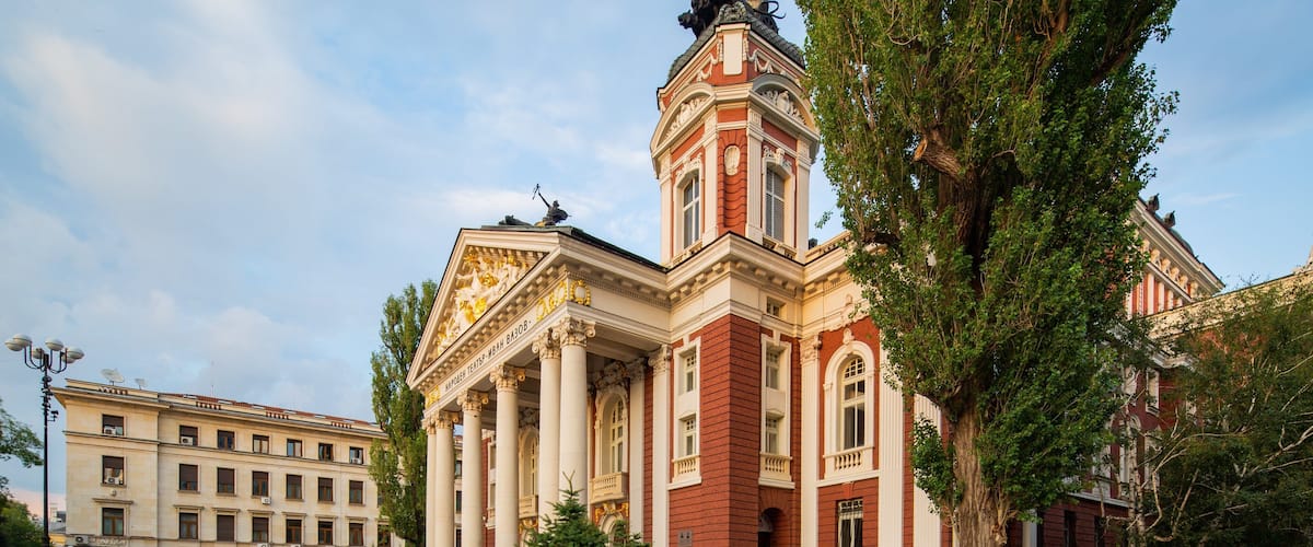 A grand building with classical architecture, featuring columns and a prominent tower.