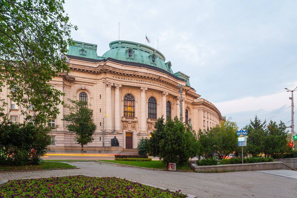 A large, historic building with a green dome and arched windows.