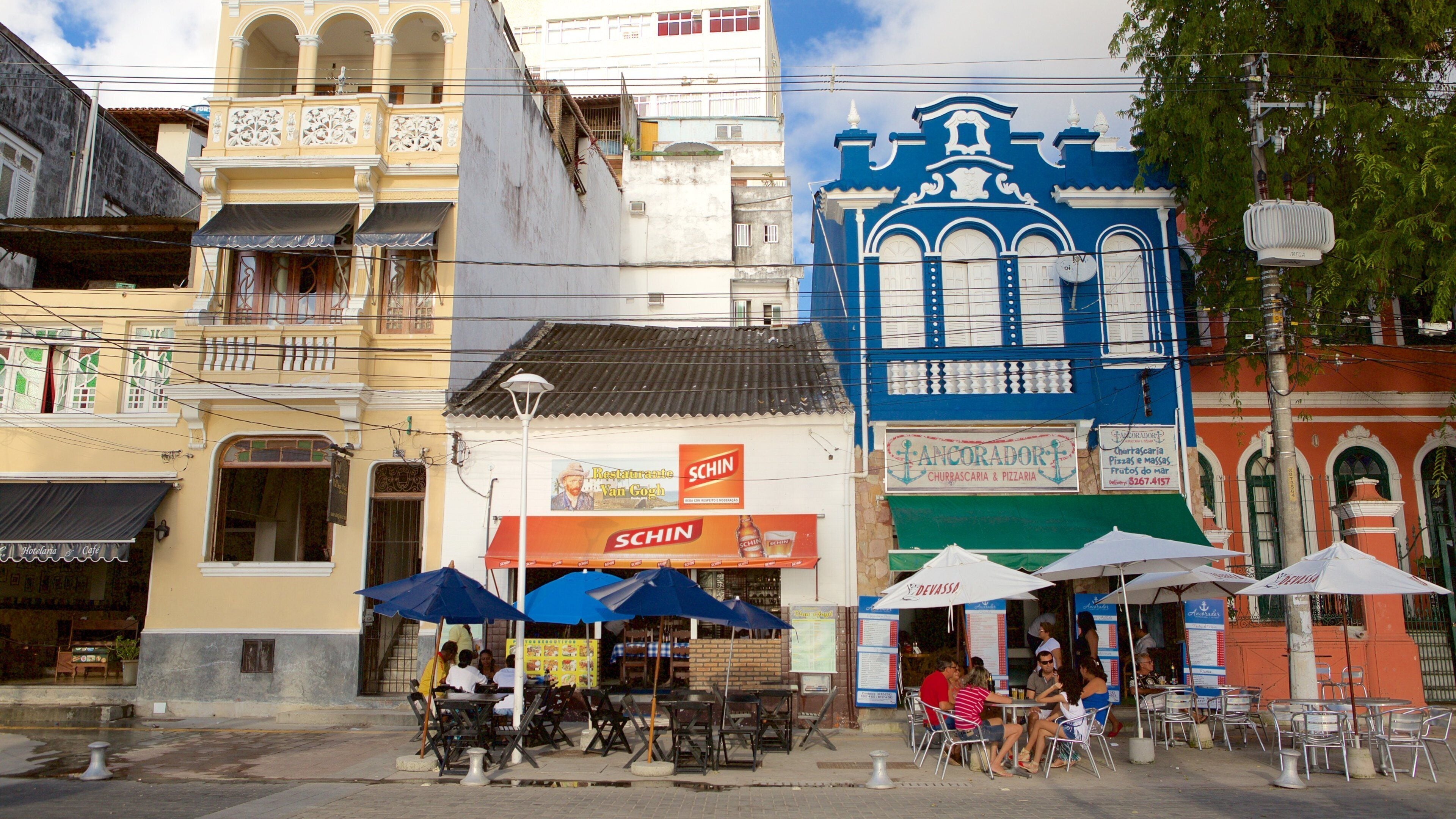 Porto da Barra Beach featuring outdoor eating as well as a small group of people