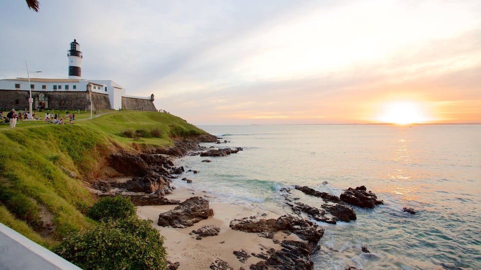 Farol da Barra Beach featuring a sunset, a lighthouse and a sandy beach