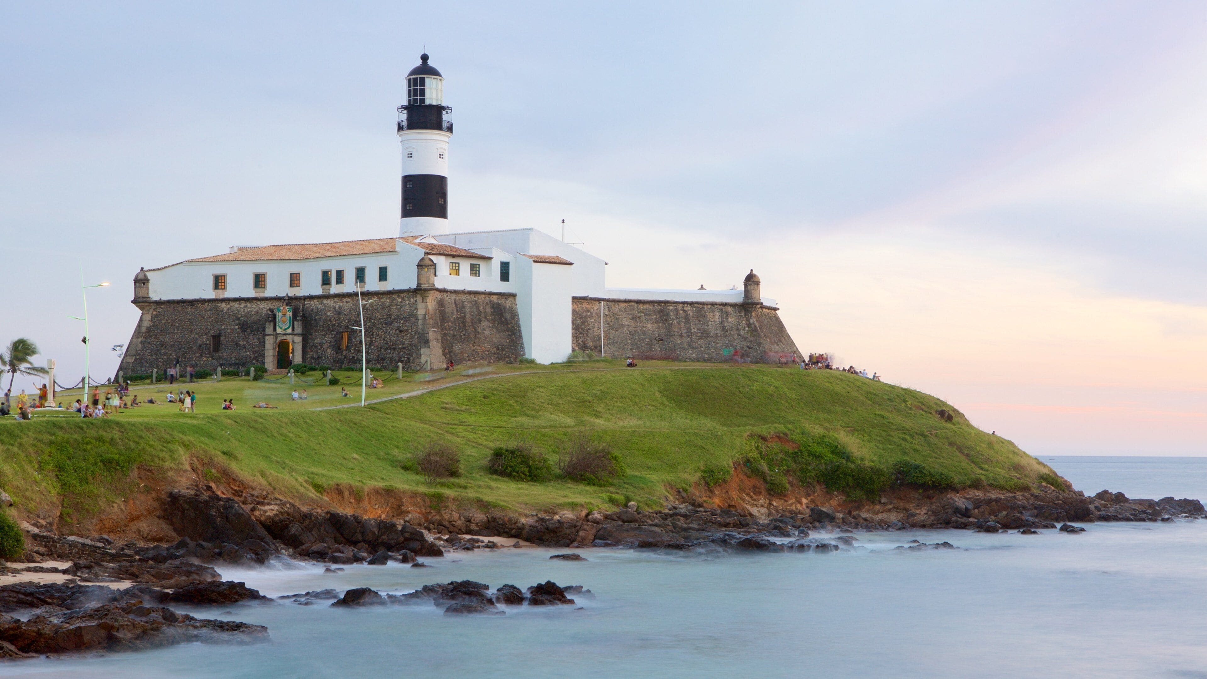 Farol da Barra Beach which includes general coastal views, a sunset and a lighthouse
