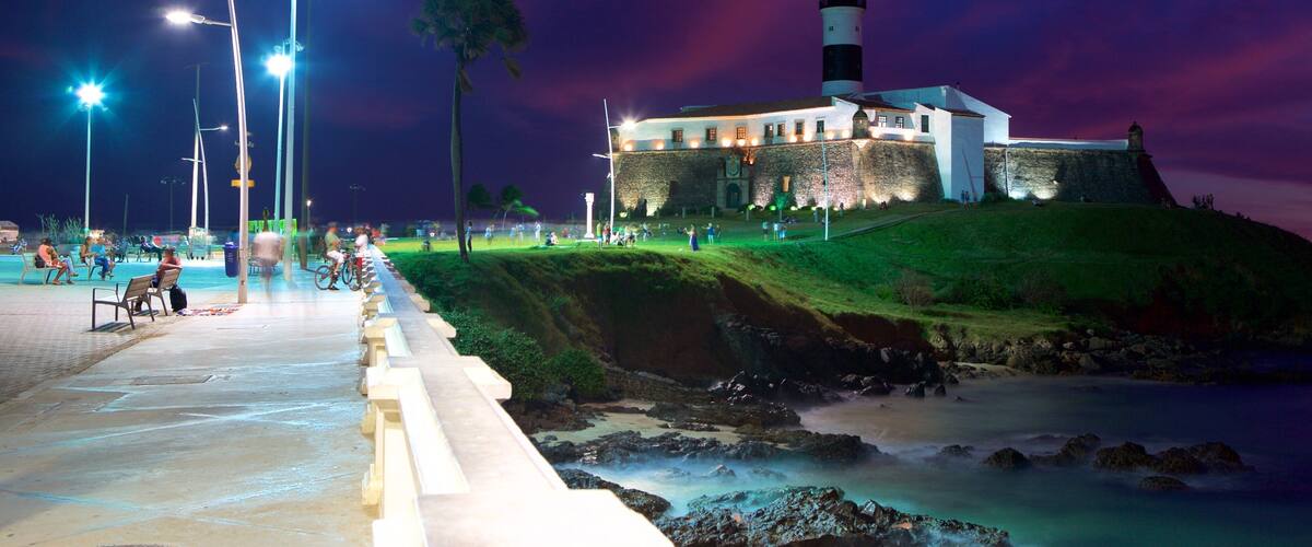 Playa Farol da Barra ofreciendo vista general a la costa, escenas de noche y un faro