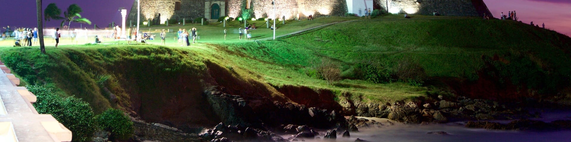 Farol da Barra Beach showing a lighthouse, a sunset and night scenes