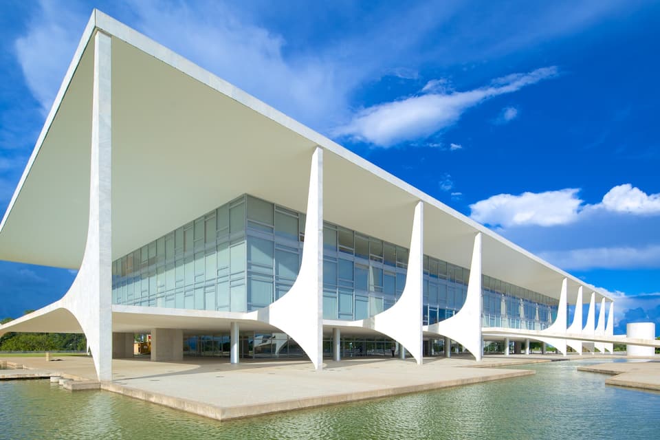 Um edifício moderno com fachada branca e estrutura de telhado triangular singular.