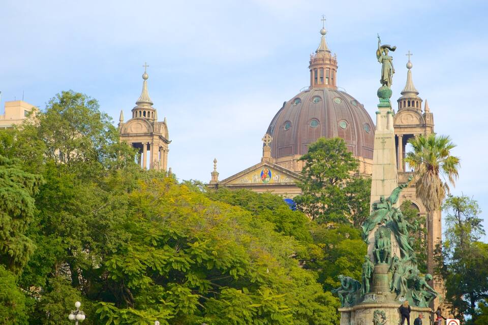 Um edifício grande com cúpula e uma estátua na frente.