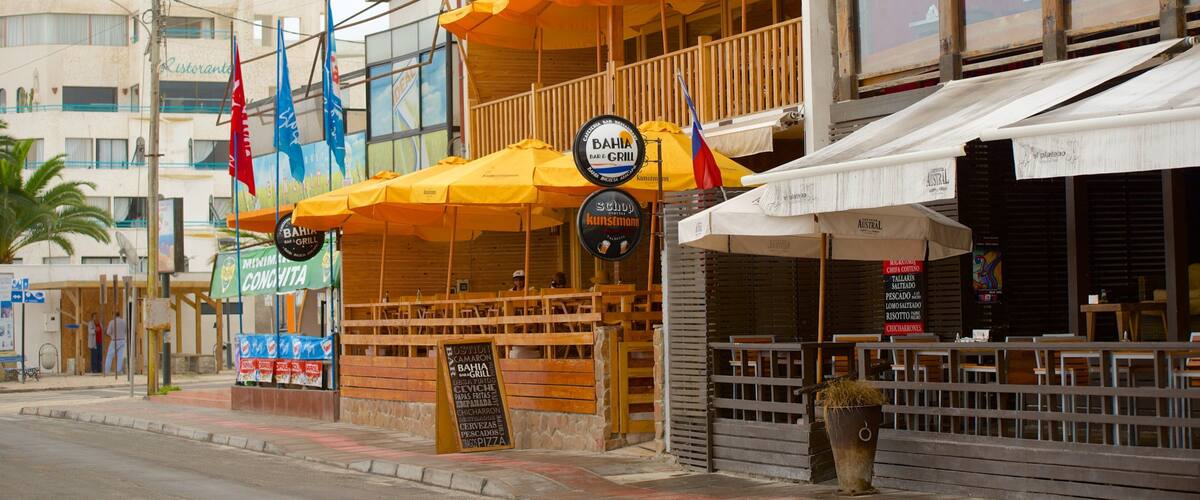 A beachfront bar and grill with outdoor seating and multiple flags.