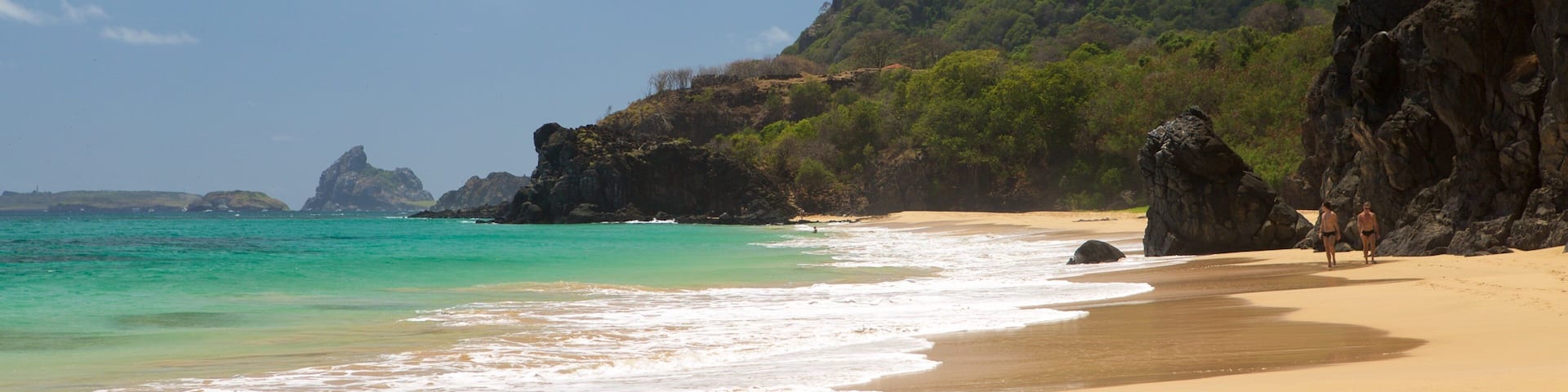 Cacimba do Padre Beach showing mountains, rocky coastline and a beach