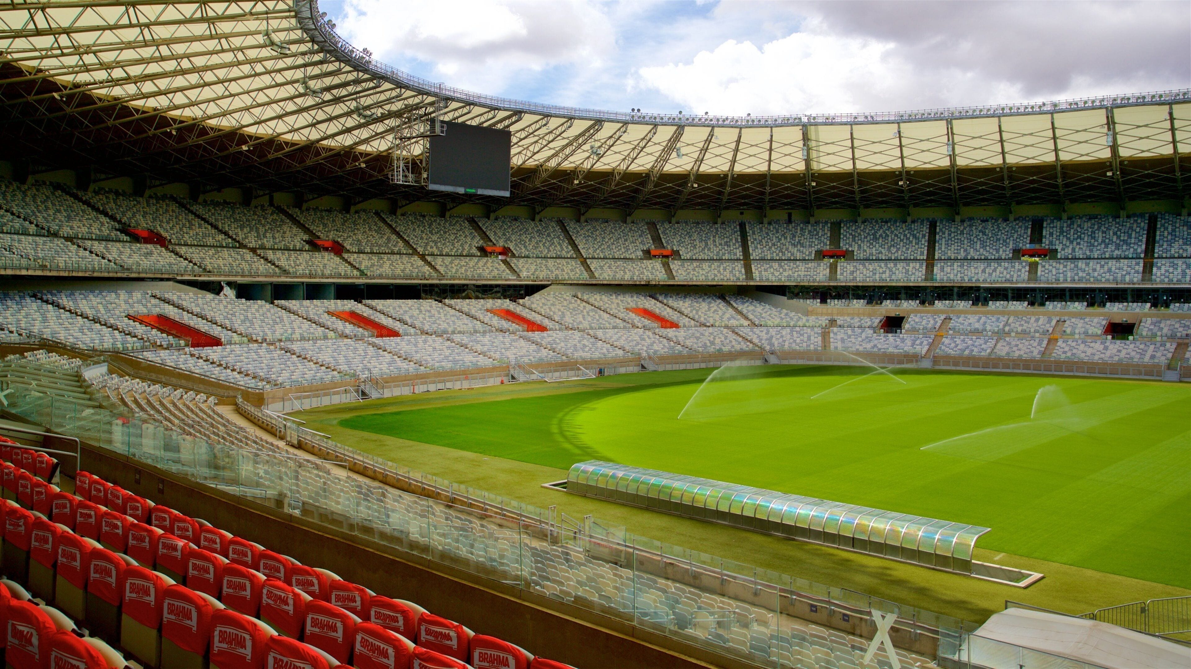 Un estadio amplio y vacío con asientos en niveles y un campo verde.