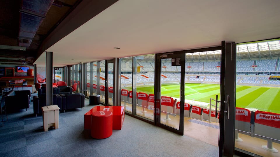 Ein Sportstadion mit roten Sitzplätzen, einer Glasbeobachtungsfläche und einem Fernsehbildschirm.
