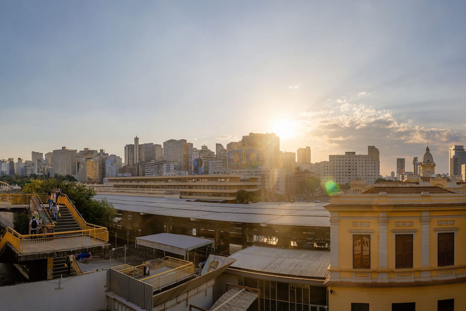 A cityscape with a prominent yellow building and a bridge with yellow railings.