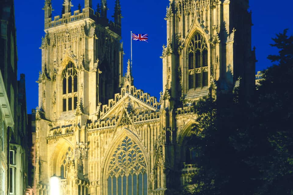A Gothic cathedral with intricate architecture and a flag.