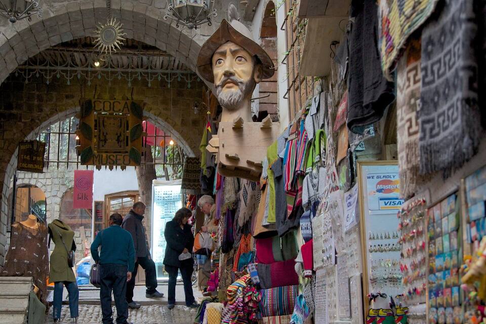 Um mercado animado com tecidos coloridos e uma grande estátua.