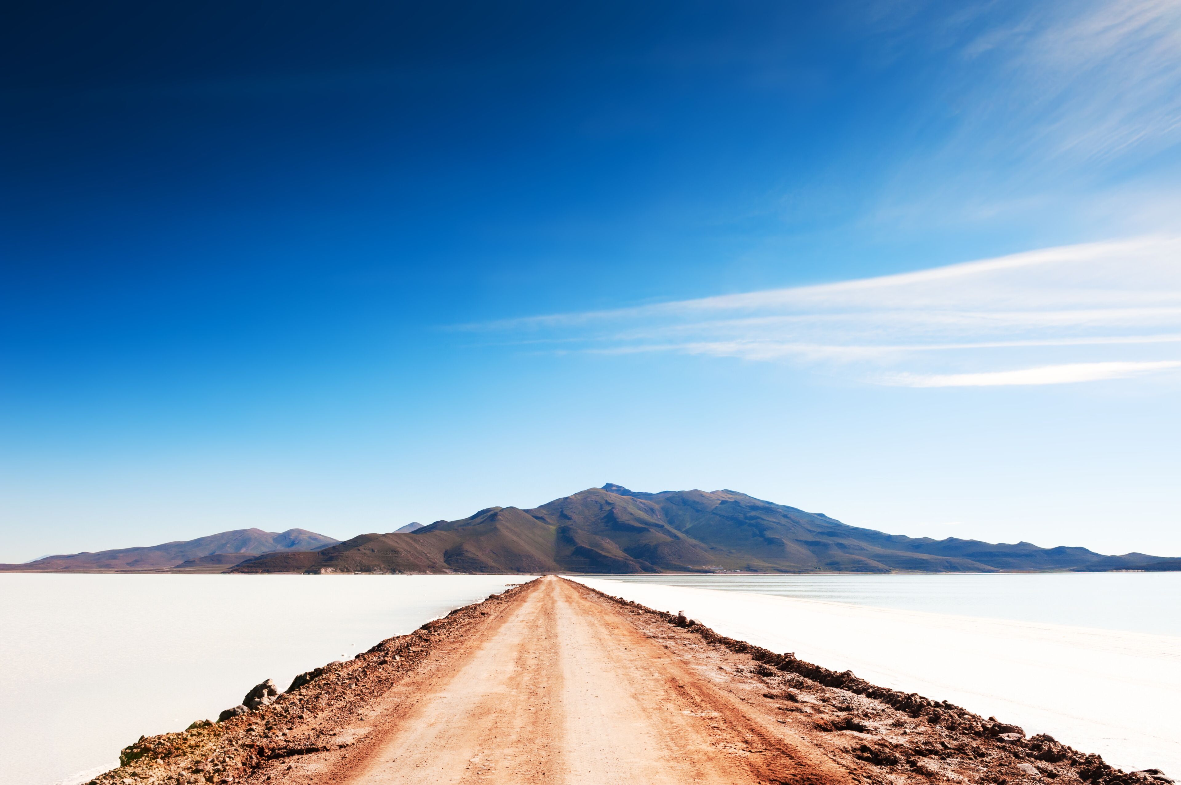 Road to volcano on Salar de Uyuni salt flat in Bolivia. South America landscapes.