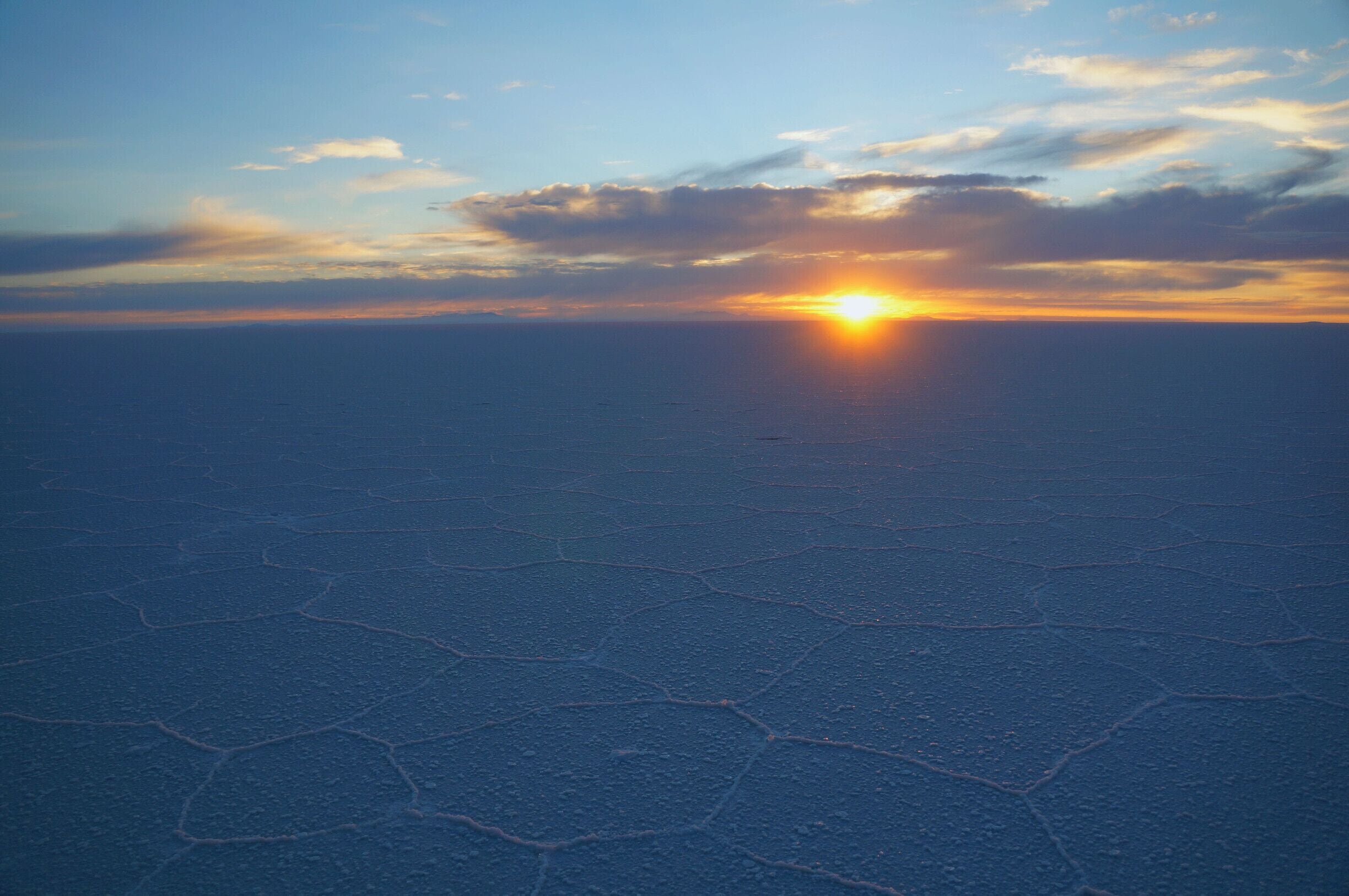 This surreal landscape in Bolivia was one of the highlights of our trip in Bolivia.  We visited the Salar on the final day of a three day jeep tour.  We awoke before dawn, to see the sun rise over the salt flats.  We drove for a few hours, with salt as far as the eye could see.  The crust has risen edges forming geometrical #patterns . Our guide even cracked the top layer, dug down into the water, and pulled up salt crystal formations. #Bolivia