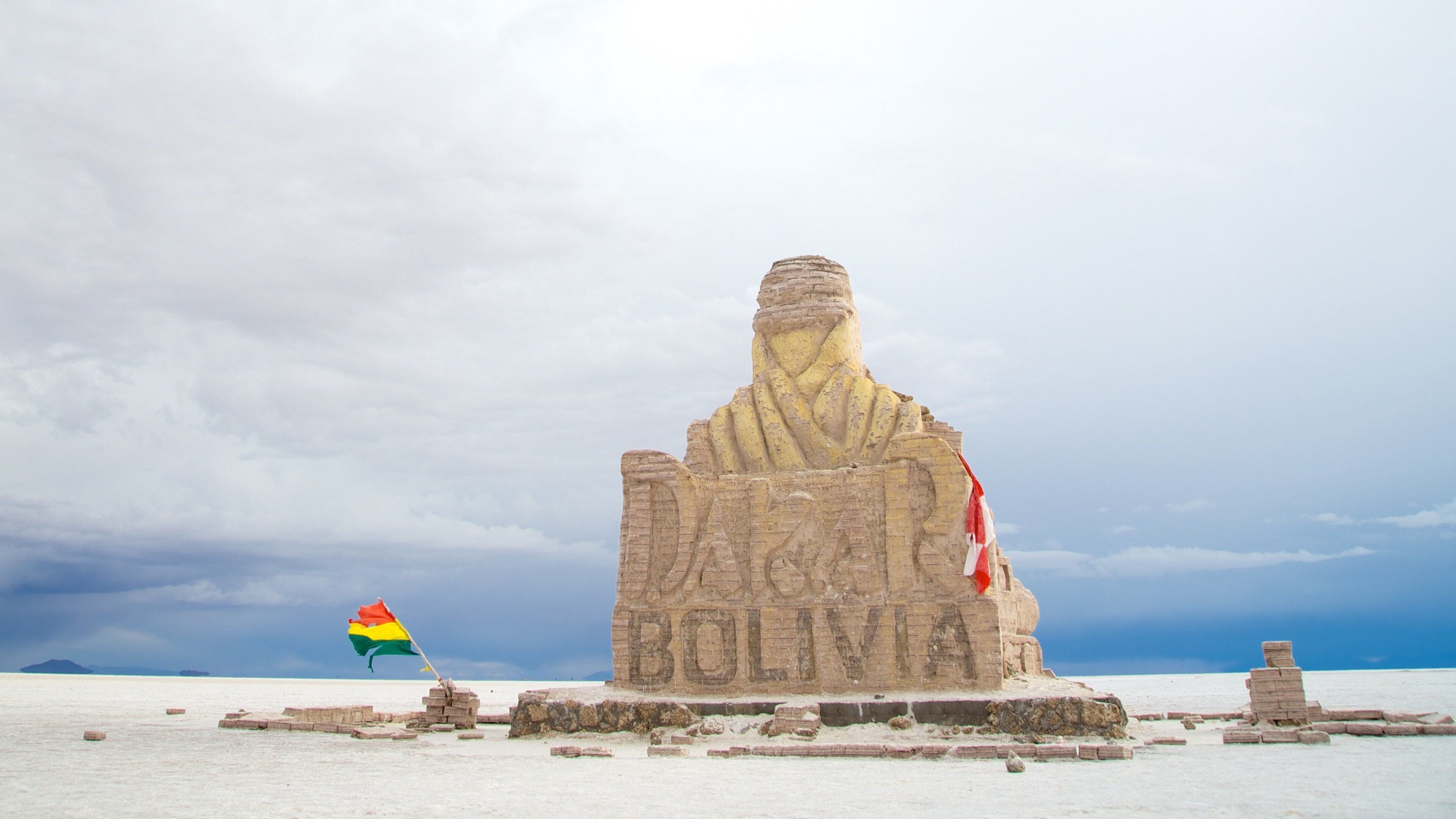 Una gran estatua de piedra con la inscripción 'BOLIVIA' e izada, con una bandera.
