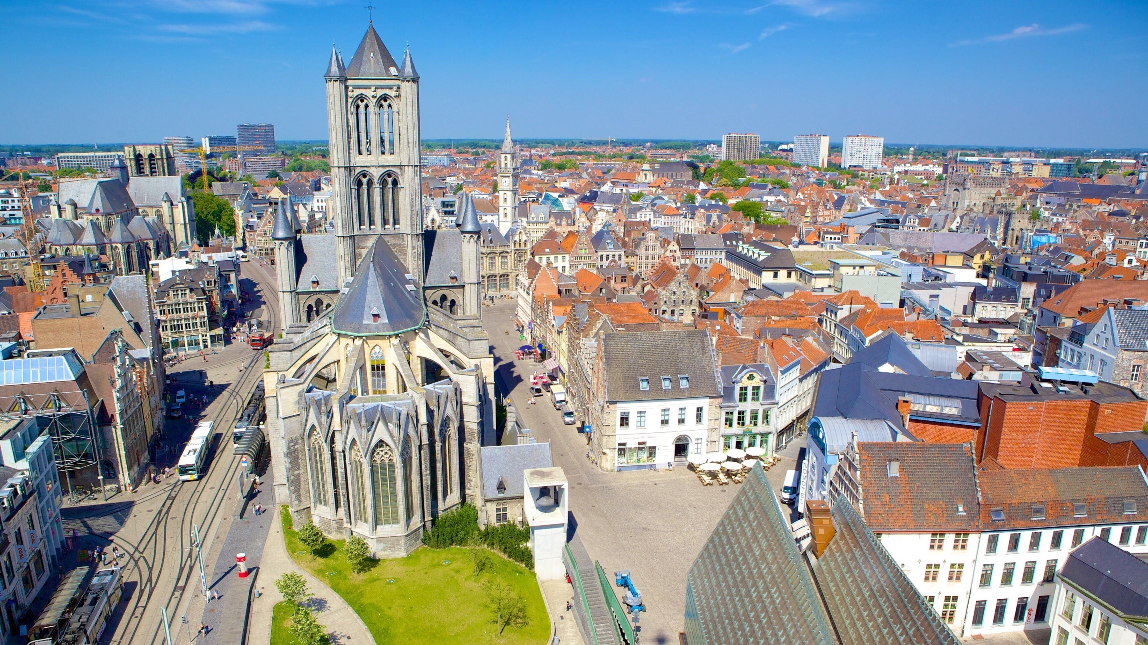 Een historische kathedraal met een hoge toren, omgeven door een dichtbebouwd stedelijk gebied met traditionele Europese architectuur.