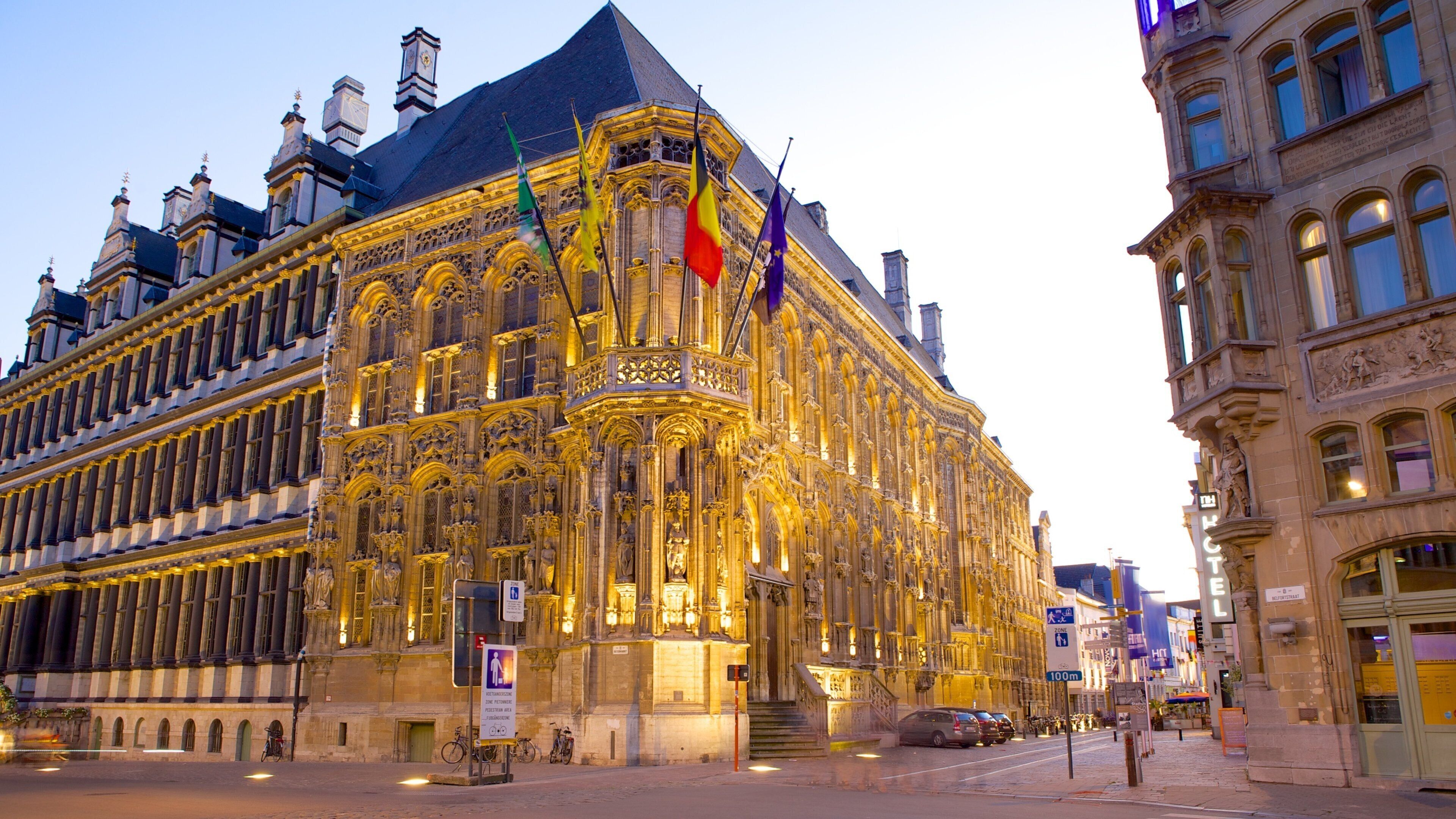 A historic building with ornate architecture and multiple flags.