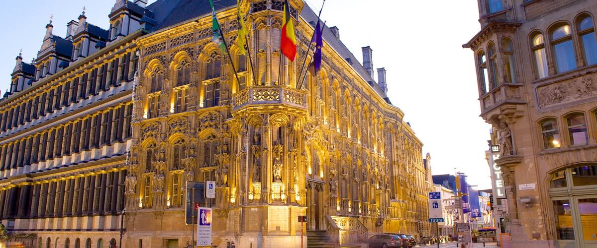 A historic building with ornate architecture and multiple flags.