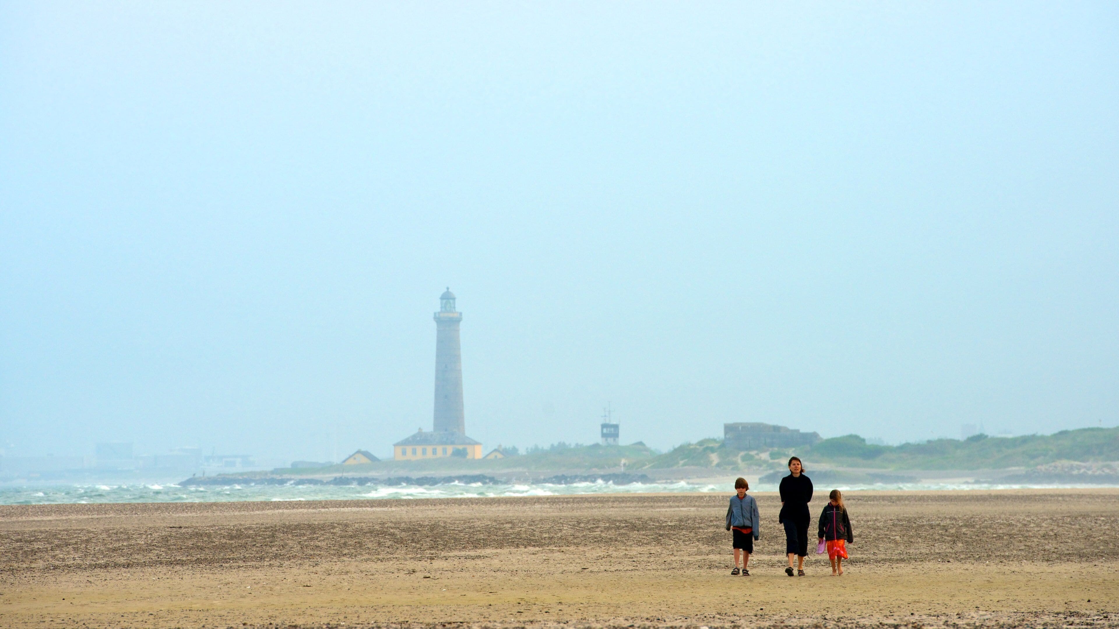 Grenen showing a lighthouse and a sandy beach as well as a family