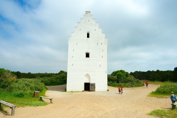 Den Tilsandede Kirke som viser en park og en kirke eller en katedral