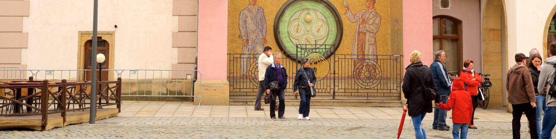 Astronomical Clock featuring heritage elements and a city as well as a small group of people