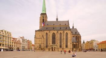 A historic church with a tall green spire and a clock tower.