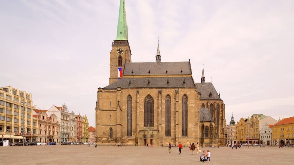 Una iglesia histórica con una aguja verde alta y una torre de reloj.