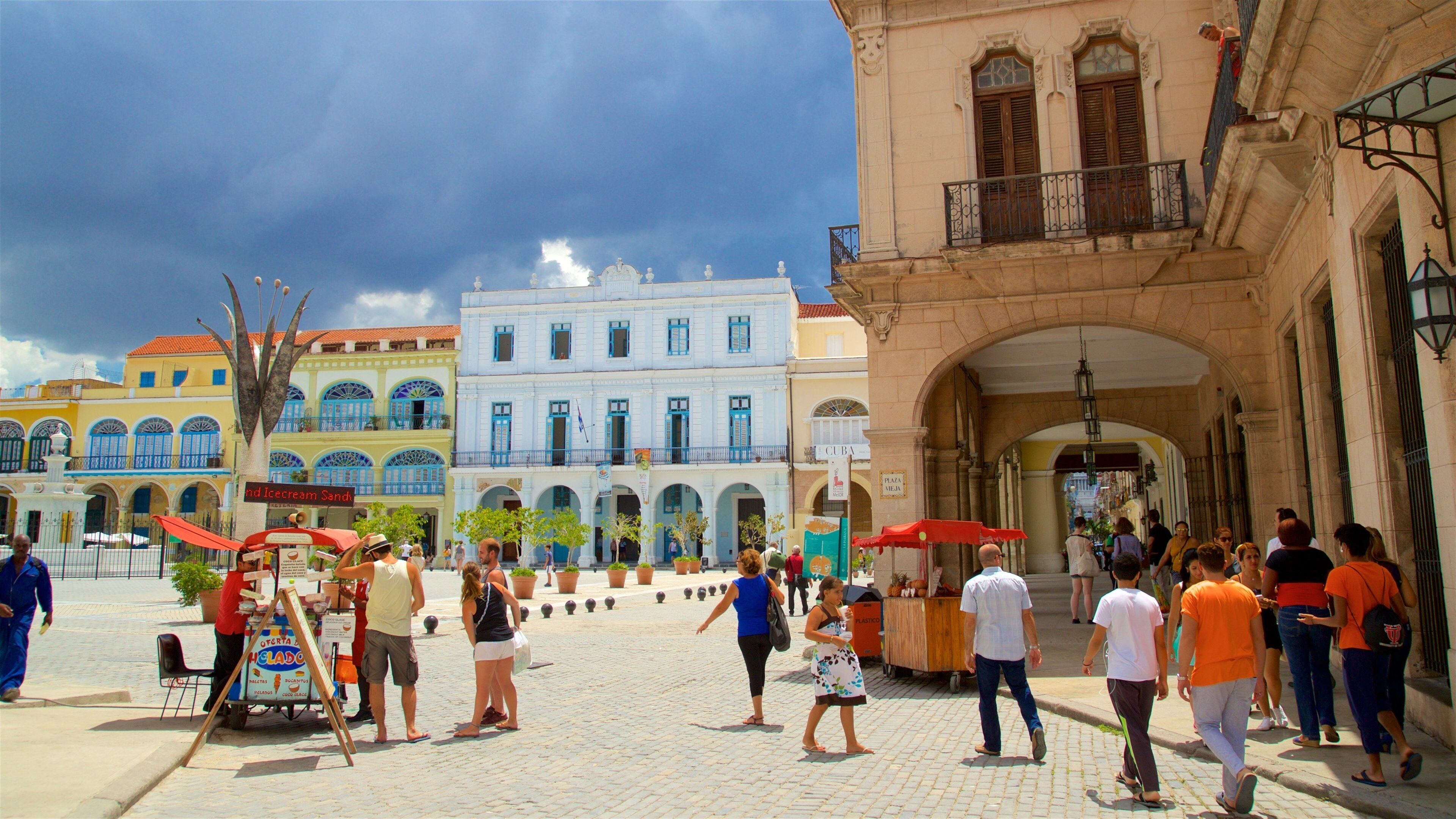 A bustling street scene with colorful buildings, a street vendor cart, and pedestrians.