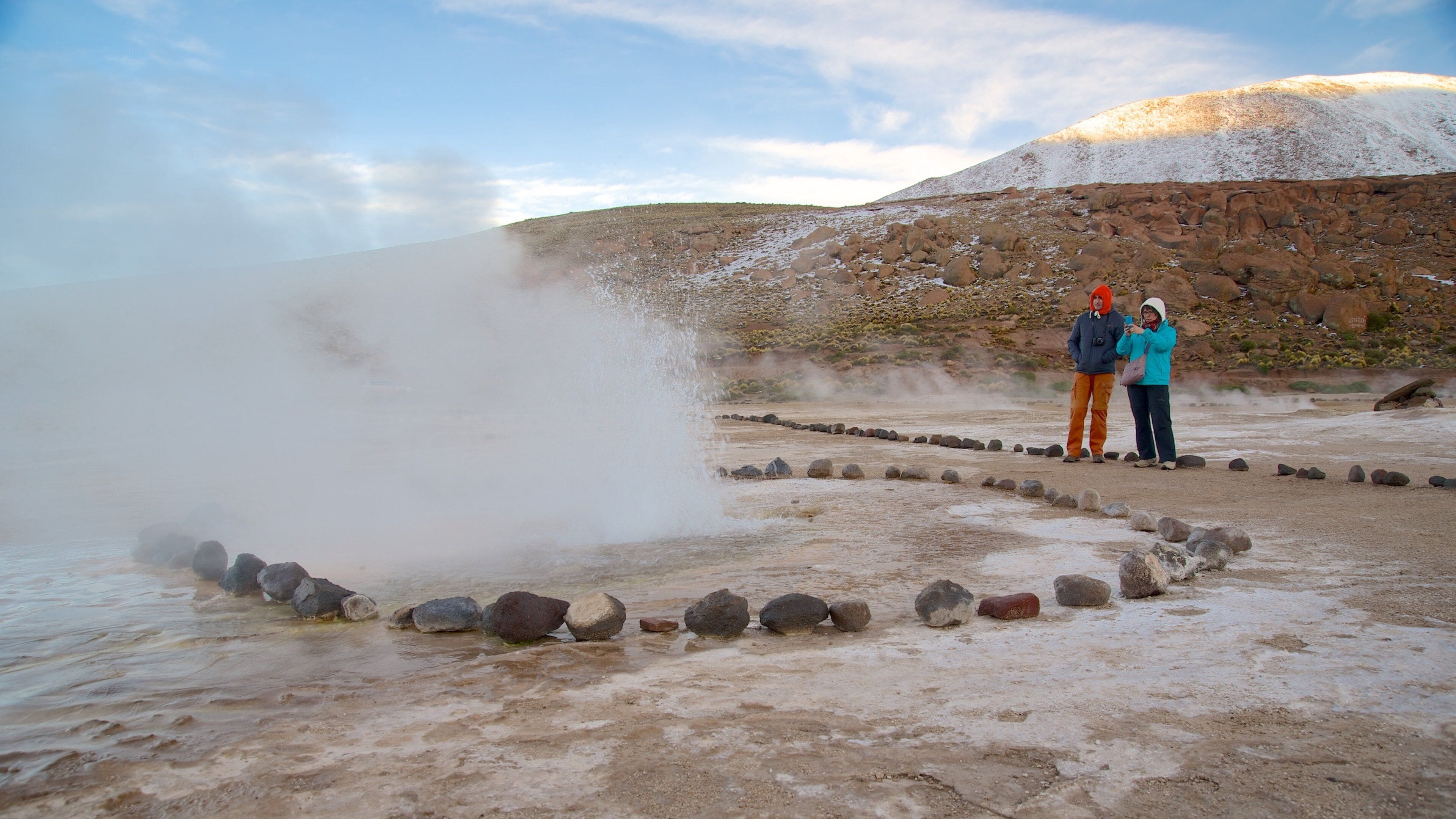 El Tatio Geyser Field welches beinhaltet ruhige Szenerie sowie kleine Menschengruppe