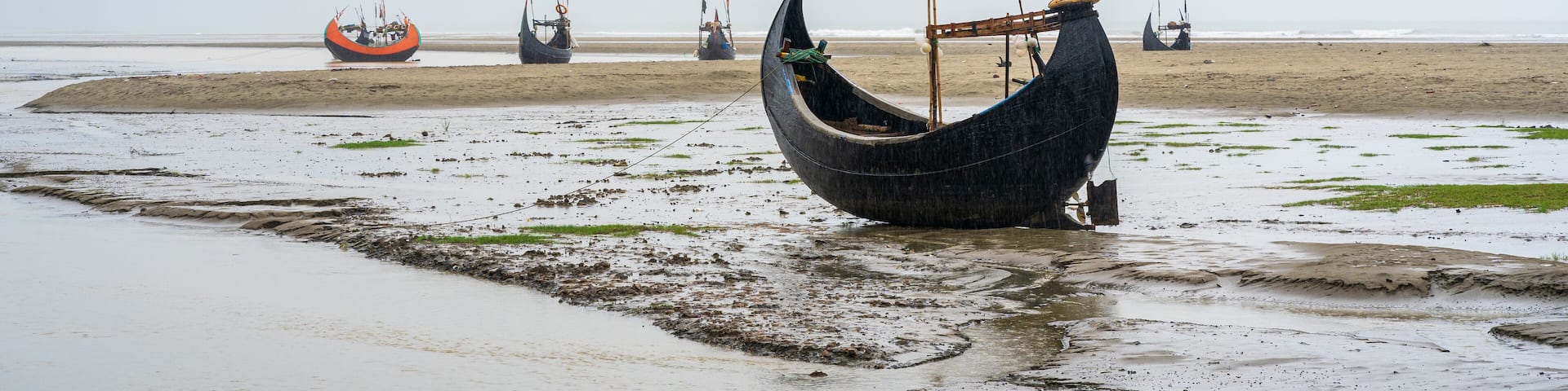 Scenic seascape panorama of beautiful traditional wooden fishing boats known as moon boats on Inani beach, Cox's Bazar, Bangladesh